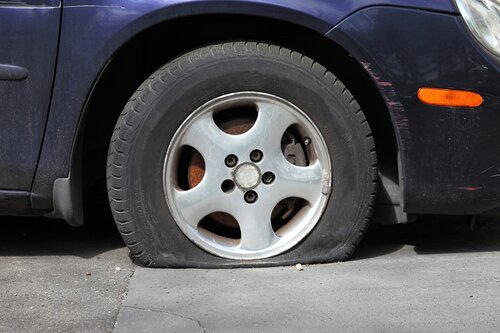 A picture of a car with a flat tire.
